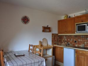 a small kitchen with a table and a microwave at Appartement 27m² à Châtel, proche des télésièges, balcon ouest, parking, Multi Pass inclus! - FR-1-693-56 in Châtel