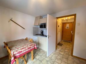 eine kleine Küche mit einem Tisch und einem kleinen Tisch sowie ein Zimmer in der Unterkunft Studio Châtel, 1 pièce, 4 personnes - FR-1-693-78 in Châtel