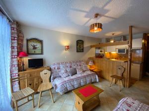 salon z kanapą i kuchnią w obiekcie Studio cosy avec Multi Pass, à 100m des remontées Linga, garage et WiFi inclus, idéal ski et été - FR-1-693-82 w mieście Châtel