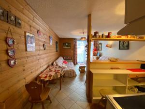 Il dispose d'une cuisine avec des murs en bois et d'une chambre avec une table. dans l'établissement Studio Châtel, 1 pièce, 4 personnes - FR-1-693-82, à Châtel