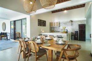 a kitchen and dining room with a wooden table and chairs at SunGlow Villa in Seminyak