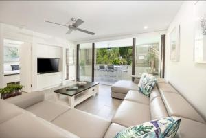 un soggiorno con divano e TV di 303 Sea Temple Renovated Apartment a Palm Cove