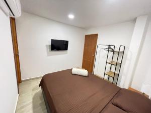 um quarto com uma cama e uma televisão na parede em Hotel La Yarolina SAS em Cartagena de Indias