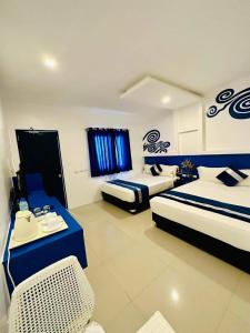 a hotel room with two beds and a table at Ruhe Suites Coron in Coron