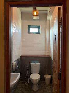 a bathroom with a toilet and a tub and a sink at Busket Hostel in Chiang Rai
