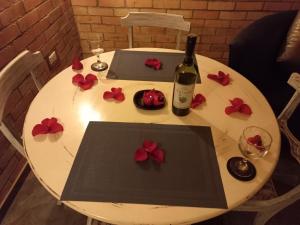 uma mesa branca com uma garrafa de vinho e flores em Cabaña Pacha Neusa em Cogua