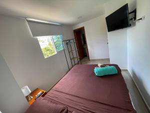 um pequeno quarto com uma cama e uma televisão de ecrã plano em Hotel La Yarolina SAS em Cartagena de Indias