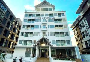 a white building with a sign on the front of it at Arsh Boutique Hotel in Chiang Mai