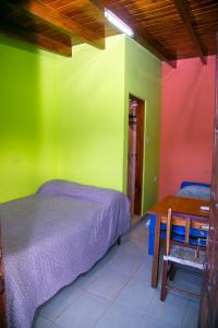 1 dormitorio con paredes de color verde y rojo, 1 cama y 1 mesa en El Shaddai en Tilcara