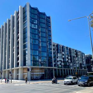 a large building with cars parked in front of it at Central Canberra City apartment with study and full amenities including parking in Canberra