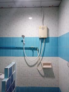 e bagno con doccia e piastrelle bianche e blu. di Kanjana Resort a Suratthani