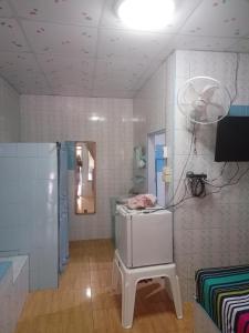 um quarto com um frigorífico e uma mesa em Kanjana Resort em Surat Thani