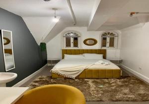 a bedroom with a bed and a yellow chair at Mollyinn Central Brighton in Brighton & Hove