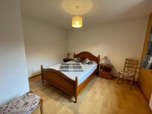 a bedroom with a bed and a lamp and a chair at Appartement La Chapelle-d'Abondance, 2 pièces, 5 personnes - FR-1-692-35 in La Chapelle-dʼAbondance