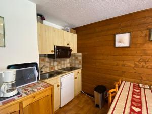 a kitchen with wooden walls and a counter with a microwave at Appartement La Chapelle-d'Abondance, 2 pièces, 6 personnes - FR-1-692-23 in La Chapelle-dʼAbondance