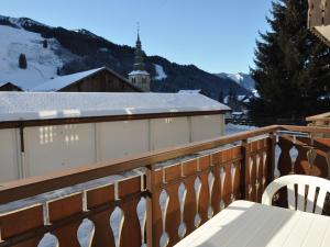 ein Balkon mit Holzgeländer und weißer Sitzbank in der Unterkunft Charmant 2 pièces au centre du village avec parking - FR-1-692-27 in La Chapelle-dʼAbondance + 4 Fotos