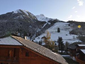 a building with a mountain in the background with snow at Studio spacieux au pied des pistes avec casier à skis - FR-1-692-31 in La Chapelle-dʼAbondance +5 photos
