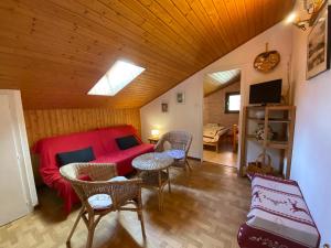 ein Wohnzimmer mit einem roten Sofa und einem Tisch in der Unterkunft Appartement 2 chambres avec balcon exposé Sud, parking et navettes à proximité - FR-1-692-39 in La Chapelle-dʼAbondance