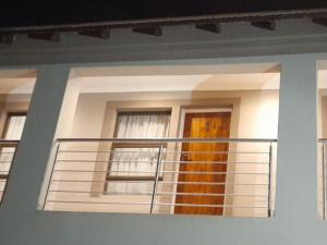 a house with a balcony with a door and windows at TLZ Prop B&B in Pretoria