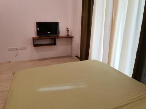 a bedroom with a bed and a tv in a room at Y Villa Residencies in Galle