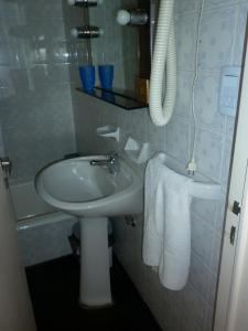 a bathroom with a white sink and a mirror at Studio Suipacha in Buenos Aires