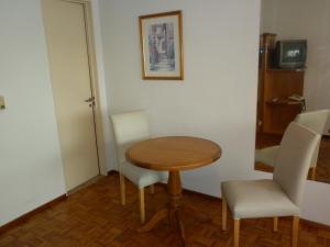 Zimmer mit einem Tisch, 2 Stühlen und einer Tür in der Unterkunft Studio Suipacha in Buenos Aires