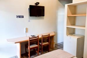 a small room with a desk and a tv on the wall at Pousada Casa Grande in Bonito