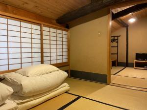 una camera con un letto nel mezzo di una stanza di Nagomi-Ryokan Yuu a Kyoto