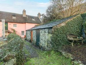 een oud stenen gebouw met een bankje ernaast bij Shortbread Cottage in Cupar