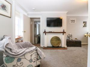 a living room with a fireplace and a tv at Shortbread Cottage in Cupar