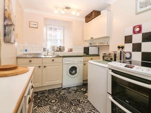 een keuken met een wasmachine en een vaatwasser bij Shortbread Cottage in Cupar