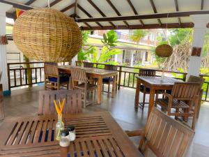 فندق بيرل آيلاند بيتش في هيكادوا: مطعم بطاولات وكراسي خشبية وثريا