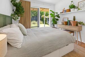 a bedroom with a large bed and a desk at PERIWINKLE - MOUNT MARTHA in Mount Martha