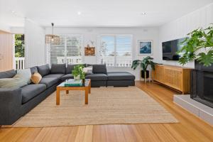 a living room with a couch and a tv at PERIWINKLE - MOUNT MARTHA in Mount Martha