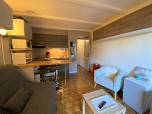 ein kleines Wohnzimmer mit einem Sofa und einer Küche in der Unterkunft Studio Châtel, 1 pièce, 4 personnes - FR-1-693-88 in Châtel