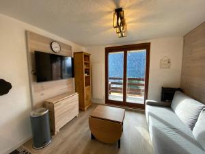 salon z kanapą i telewizorem w obiekcie Appartement charmant avec parking, proximité centre et télécabine - FR-1-693-93 w mieście Châtel