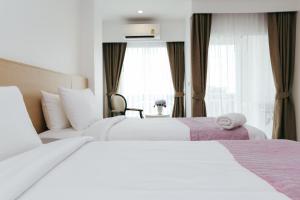 Cette chambre comprend 2 lits et une fenêtre. dans l'établissement Arsh Boutique Hotel, à Chiang Mai
