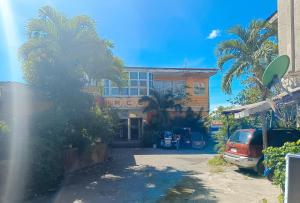 un edificio con palme di fronte ad esso di RedDoorz @ Grand Valley Hotel Junction Luna Cagayan a Colonia Parcela Number One