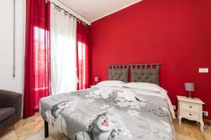 um quarto com uma parede vermelha e uma cama em L'Imperiale RomaTrastevere em Roma