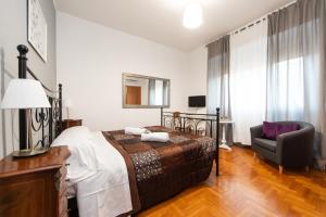 a bedroom with a bed and a chair in it at L'Imperiale RomaTrastevere in Rome