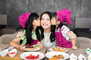 Trois jeunes filles murmurant sur leur visage à une table avec de la nourriture dans l'établissement Crowne Plaza Bandung, an IHG Hotel, à Bandung