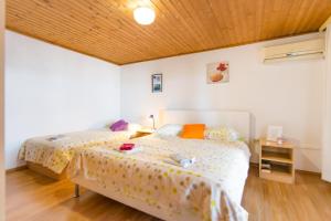 1 Schlafzimmer mit 2 Betten und Holzdecke in der Unterkunft Apartments Mare 1 - close to the sea in Biograd na Moru