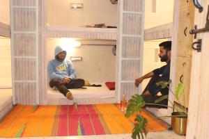 um homem sentado dentro de uma casa de brincar em Bunkyard Hostel em Udaipur