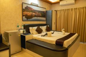 sypialnia z dużym łóżkiem i biurkiem w obiekcie Seasons Suites - JP Nagar w mieście Bengaluru