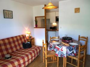 ein Wohnzimmer mit einem Tisch und einem Sofa in der Unterkunft Appartement Bagnères-de-Luchon, 2 pièces, 4 personnes - FR-1-313-127 in Luchon