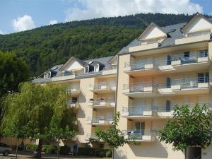 ein großes Apartmenthaus mit einem Berg im Hintergrund in der Unterkunft Appartement Bagnères-de-Luchon, 2 pièces, 4 personnes - FR-1-313-127 in Luchon