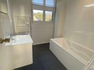 a white bathroom with a tub and a sink at Grande Maison Rénovée 3* à Bénodet, Jardin Clos, Salle de Jeux, Parking, Wifi, Terrasse, 4 chambres - FR-1-481-112 in Bénodet +25 photos