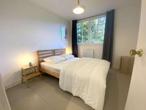 a bedroom with a large bed with a window at Grande Maison Rénovée 3* à Bénodet, Jardin Clos, Salle de Jeux, Parking, Wifi, Terrasse, 4 chambres - FR-1-481-112 in Bénodet