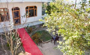 a house with a red rug in front of a yard at Three bedroom house with private garden in Solan