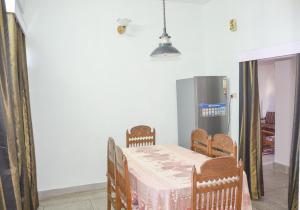 a dining room with a table and a refrigerator at Three bedroom house with private garden in Solan